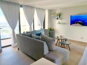 a living room with a couch and a large window at Ocean View Condo in Mazatlán