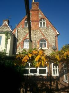 a red brick building with white windows and a tree at Rowlands Castle No 41 in Rowlands Castle