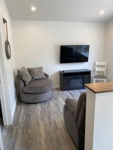 - un salon avec deux chaises et une télévision à écran plat dans l'établissement Compass Cove Cottage Oceanfront and Private trails, à Waweig 18 autres photos