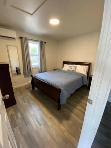 une chambre avec un lit et un parquet dans l'établissement Compass Cove Cottage Oceanfront and Private trails, à Waweig