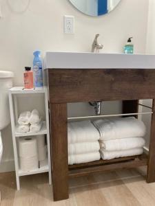 La salle de bains est pourvue d'un lavabo et d'un tas de serviettes. dans l'établissement Compass Cove Cottage Oceanfront and Private trails, à Waweig