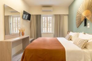 a bedroom with a large bed and a mirror at Lidra Rooms in Chania