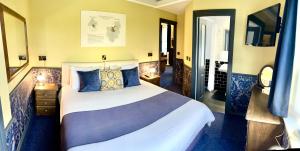 um quarto com uma cama grande e almofadas azuis em Atlantis Holiday Apartments em Torquay
