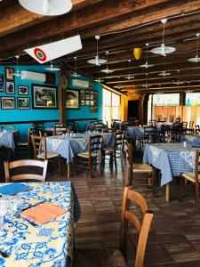 een restaurant met tafels en stoelen met blauw en wit linnengoed bij Hotel Softwood in Recanati