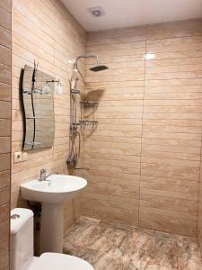 uma casa de banho com um lavatório e um WC em Apartments NITA em Batumi