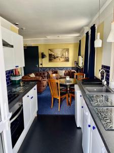 een keuken met een tafel en een woonkamer bij Atlantis Holiday Apartments in Torquay
