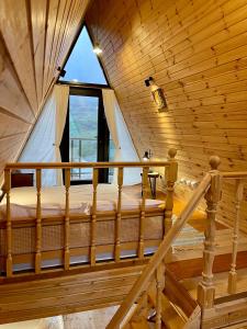 un letto in una camera con una grande finestra di Kuro cottage- A frame a Kazbegi