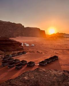 a group of chairs in the desert at sunset at Salem Wadi Rum Road in Wadi Rum
