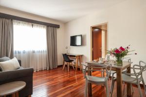 uma sala de estar com uma mesa e cadeiras e um sofá em Argenta Tower Hotel & Suites em Buenos Aires