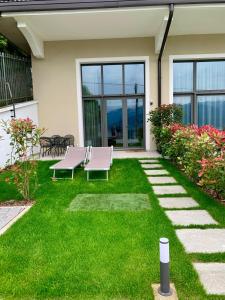 eine Terrasse mit zwei Stühlen und einem Tisch im Gras in der Unterkunft Panorama Loft Apartments in Stresa