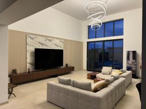 a living room with a couch and a flat screen tv at Grande Villa de vacances région de bordeaux in Ambarès-et-Lagrave