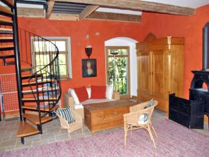 uma sala de estar com paredes cor de laranja e uma escada em espiral em Villa Rosencottage by Interhome em Heyda