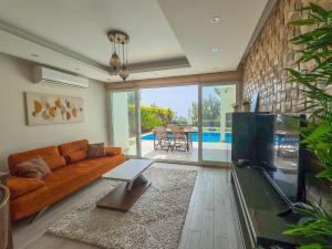 a living room with a couch and a tv at Exclusive Villas in Kuşadası