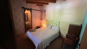 1 dormitorio con cama blanca y espejo en Bed&Breakfast la Cabanya de Beget, en Beget
