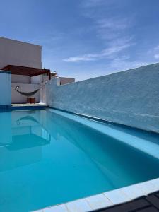 a swimming pool with a chair next to a building at INMOTEGA - Suites TG in San Luis Potosí