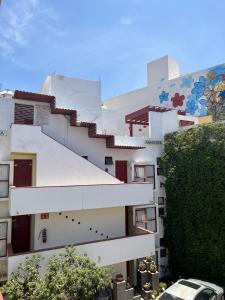 un edificio blanco con un mural en el costado en INMOTEGA - Suites TG en San Luis Potosí