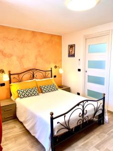 a bedroom with a large bed with yellow and black pillows at Archetto-casa vacanze in Enna