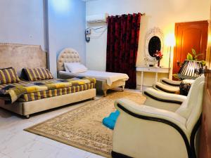 a living room with couches and a couch and a table at Aimys Villa Guest House in Multan