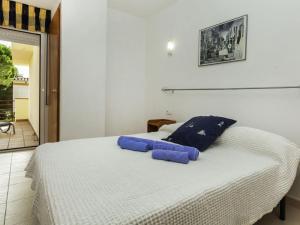 a bedroom with a bed with blue pillows on it at Holiday Home Mar Nou by Interhome in Llança
