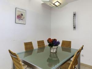 a glass table with a vase of flowers on it at Holiday Home Mar Nou by Interhome in Llança +18 photos