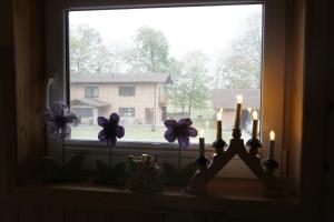 a window with candles and flowers on a window sill at Usadba Bogach in Kobryn