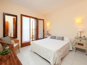 1 dormitorio con 1 cama blanca y 1 silla en Holiday Home Mas Rovira 8 by Interhome, en Bellcaire dʼEmpordà