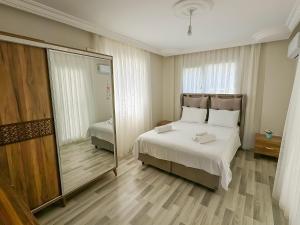 1 dormitorio con cama y espejo grande en Begonville Villas Ladies Beach, en Kusadasi