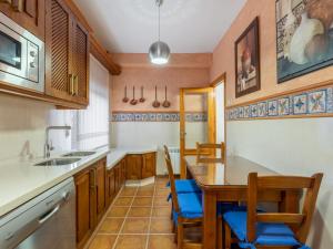 eine Küche mit Holzschränken sowie einem Tisch und Stühlen in der Unterkunft Holiday Home Villa San Vicente by Interhome in Baena