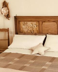 a bed with two white pillows and a wooden headboard at La Serra Sognante Guest house con giardino in Florence