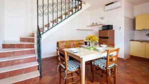 cocina y comedor con mesa y sillas en Villa Cala Liberotto, en Cala Liberotto