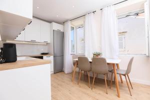 uma cozinha e sala de jantar com mesa e cadeiras em Patras Luxury Apartment em Corfu Town