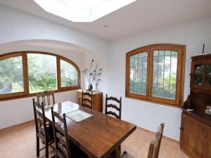 a dining room with a wooden table and windows at Holiday Home Reny by Interhome in L'Ampolla