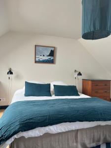 sypialnia z dużym łóżkiem z niebieskimi poduszkami w obiekcie La vigie d'Héloïse, appartement de l'Aod w mieście Lampaul