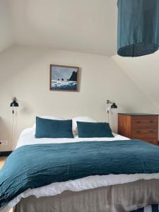 a bedroom with a large bed with blue pillows at La vigie d'Héloïse, appartement de l'Aod in Ouessant
