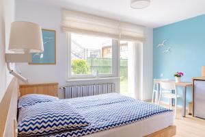 a bedroom with a bed and a table and a window at BOSMAN Karwia - Pokoje 100m od Plaży in Karwia