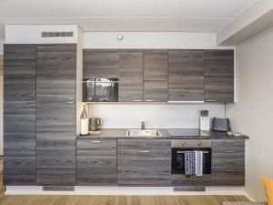 a kitchen with wooden cabinets and a sink at Holiday Home Levistar vi as- 6108 by Interhome in Levi