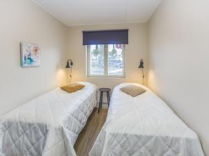 two beds in a room with a window at Holiday Home Levistar vi as- 6108 by Interhome in Levi