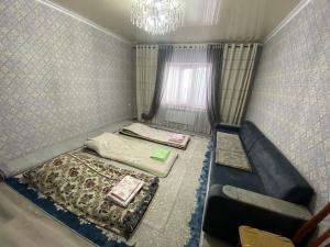 ein kleines Zimmer mit 2 Betten und einem Fenster in der Unterkunft Monchok Guest House in Naryn