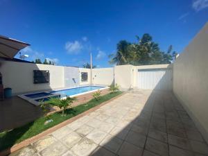 a house with a swimming pool and a white fence at CASA BRISA MAR DELUXE - Maragogi in Maragogi