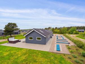 a tiny house with blue benches in a yard at Holiday Home Amai - 4-5km from the sea by Interhome in Tagholm