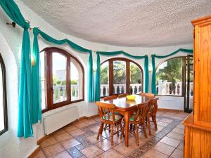 ein Esszimmer mit Tisch und Stühlen und Fenstern in der Unterkunft Holiday Home Vina by Interhome in Jávea + 17 Fotos