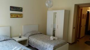 a bedroom with two beds and a mirror at FamilyBed Roma Monteverde-Vaticano in Rome