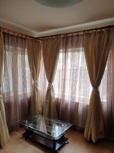 a room with curtains and a glass table in front of a window at MAMAIA FALEZA NORD in Constanţa