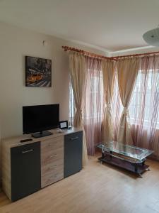 a living room with a flat screen tv and a glass table at MAMAIA FALEZA NORD in Constanţa