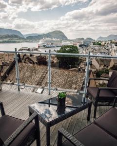 a balcony with a table with a plant on it at Panorama Apartment with 360 view of the city Ålesund in Ålesund +21 photos