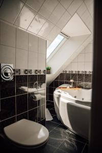 a bathroom with a toilet and a tub and a sink at Panorama Apartment with 360 view of the city Ålesund in Ålesund