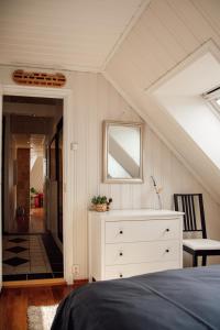 a bedroom with a white dresser and a mirror at Panorama Apartment with 360 view of the city Ålesund in Ålesund