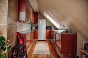 a kitchen with wooden cabinets and a white refrigerator at Panorama Apartment with 360 view of the city Ålesund in Ålesund