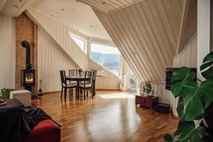 a living room with a table and chairs and a large window at Panorama Apartment with 360 view of the city Ålesund in Ålesund