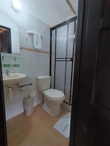 a bathroom with a toilet and a sink at Hotel Campestre Casona del Camino Real in San Gil